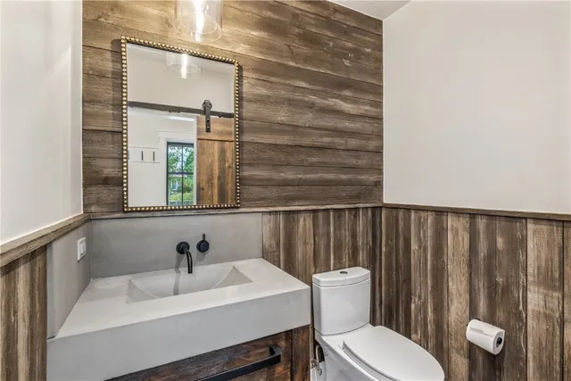 a bathroom with a toilet a sink and mirror