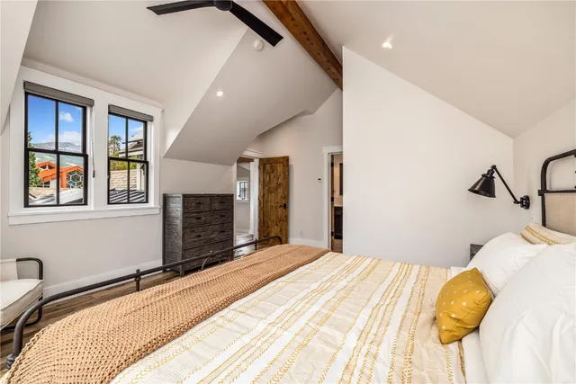 a bedroom with a bed dresser and a large window