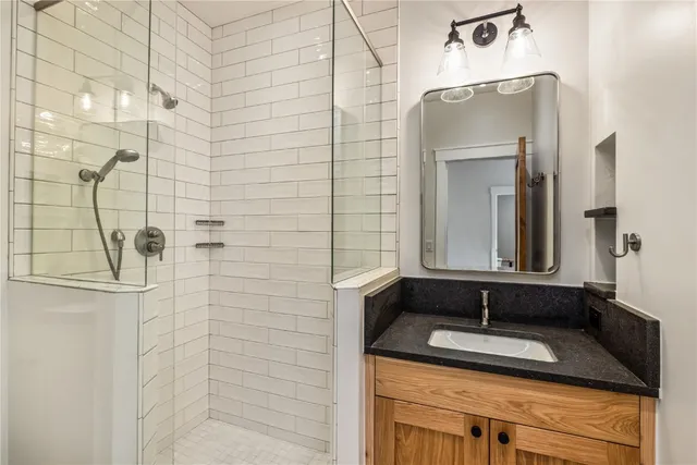 a bathroom with a granite countertop sink and mirror