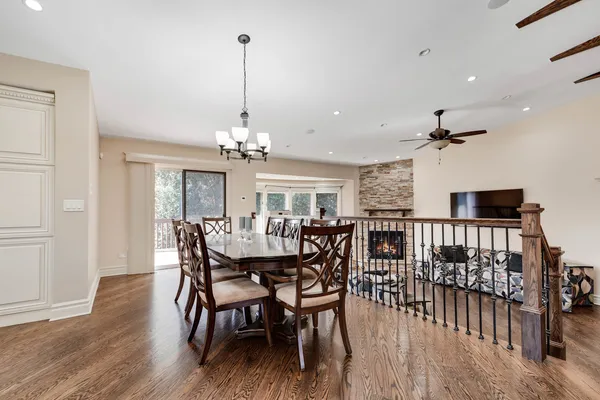 a view of a dining room and livingroom with furniture wooden floor a chandelier
