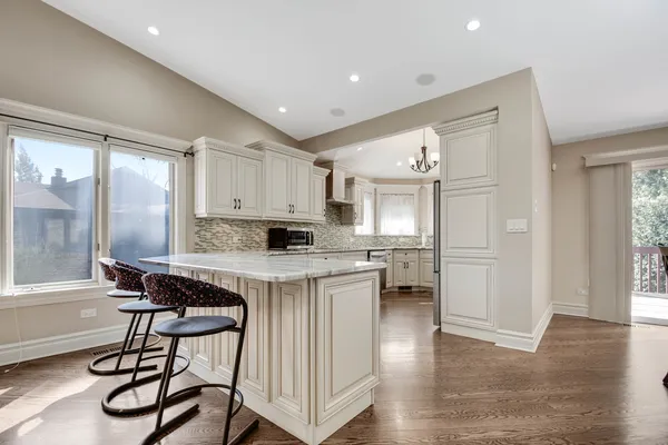 a kitchen with stainless steel appliances a table and chairs in it