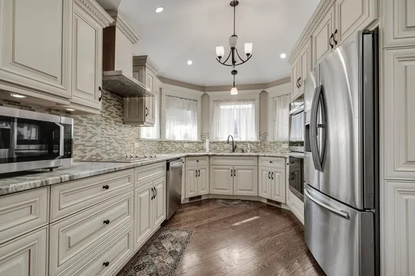a kitchen with kitchen island granite countertop stainless steel appliances cabinets a sink and a counter top space