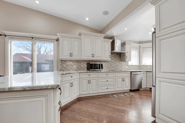 a kitchen with granite countertop white cabinets and white appliances