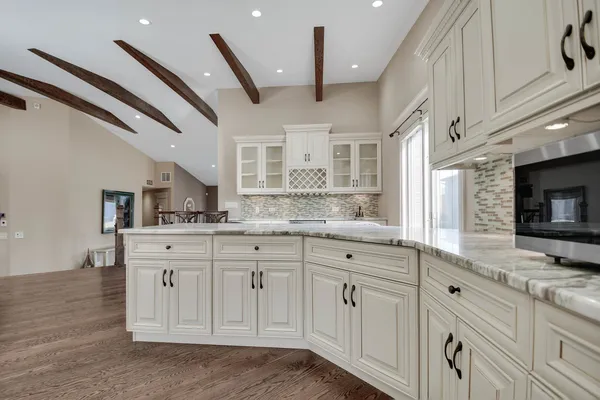 a kitchen with granite countertop a sink stainless steel appliances and cabinets