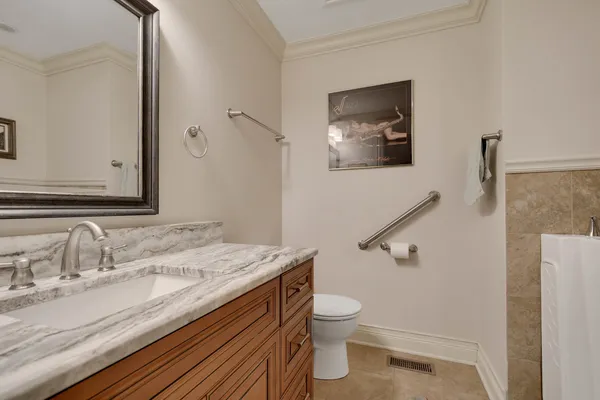 a bathroom with a granite countertop sink mirror vanity and toilet