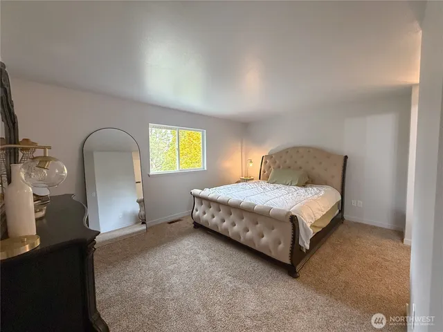 a bedroom with a bed chair and a window