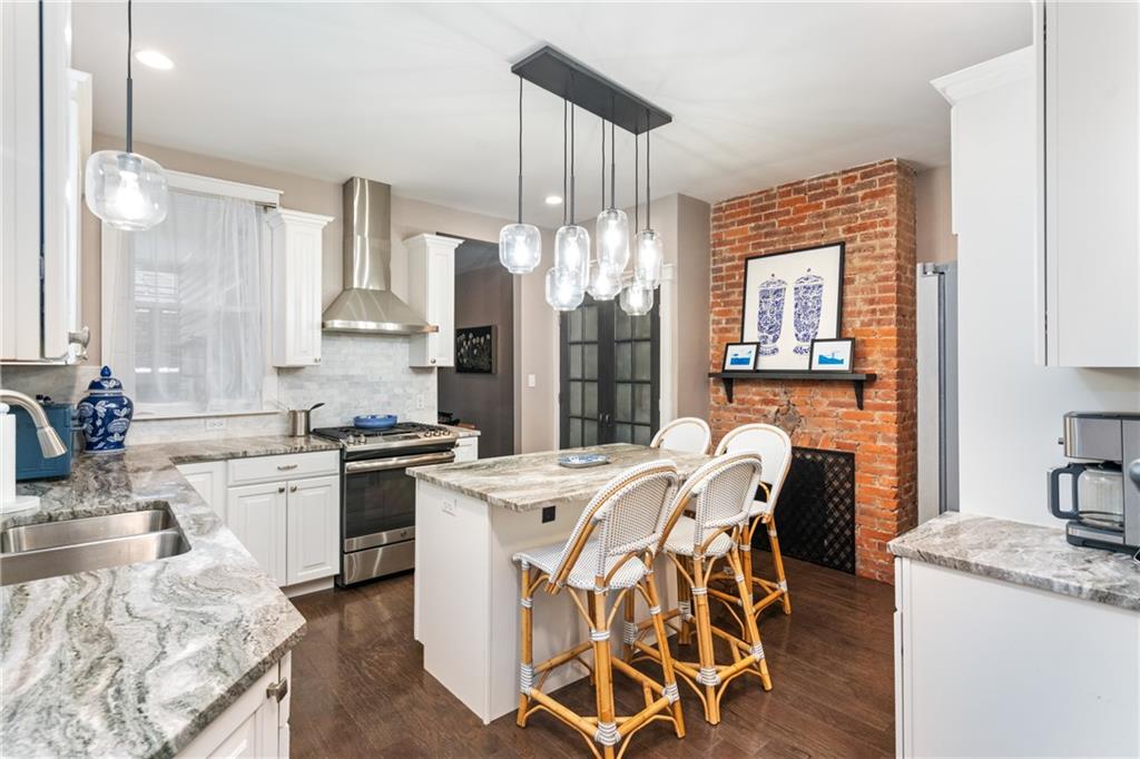 5208 Keystone Street Pittsburgh, PA 15201 - Photo 5 of 23 a kitchen that has a table chairs in it wooden floors and white cabinets