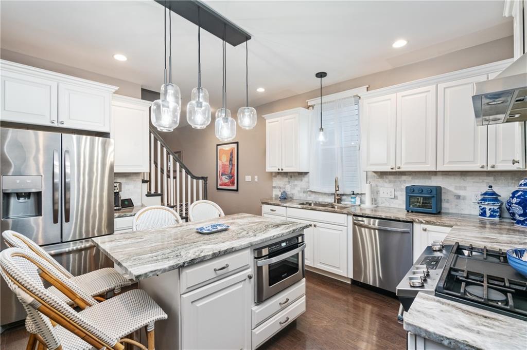 5208 Keystone Street Pittsburgh, PA 15201 - Photo 7 of 23 a kitchen with a stove a sink a dining table and chairs
