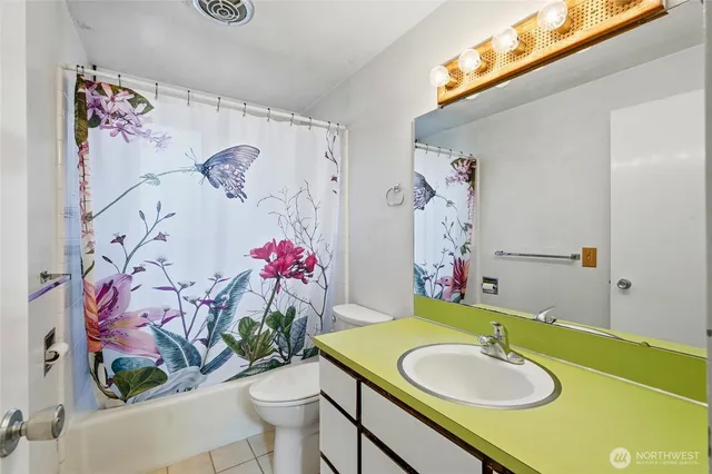 a bathroom with a sink mirror vanity and toilet