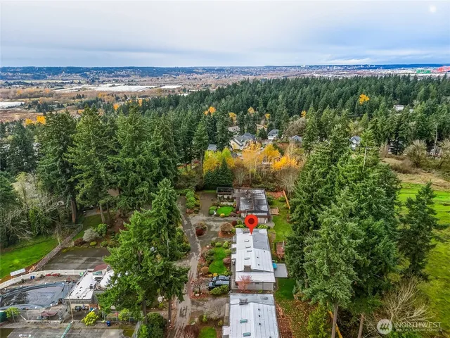 an aerial view of a city with lots of residential buildings ocean and mountain view in back