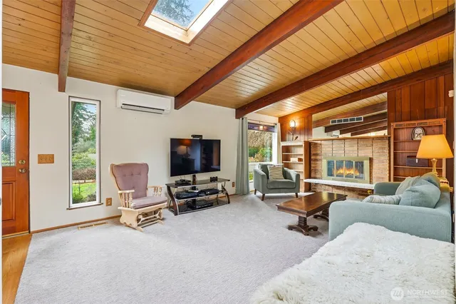 a living room with furniture a flat screen tv and large window