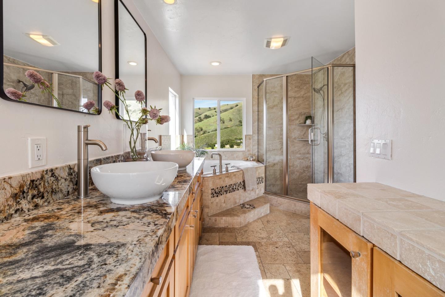 320 El Caminito Road Carmel Valley, CA 93924 - Photo 30 of 62 a spacious bathroom with a granite countertop sink a mirror a bathtub and shower