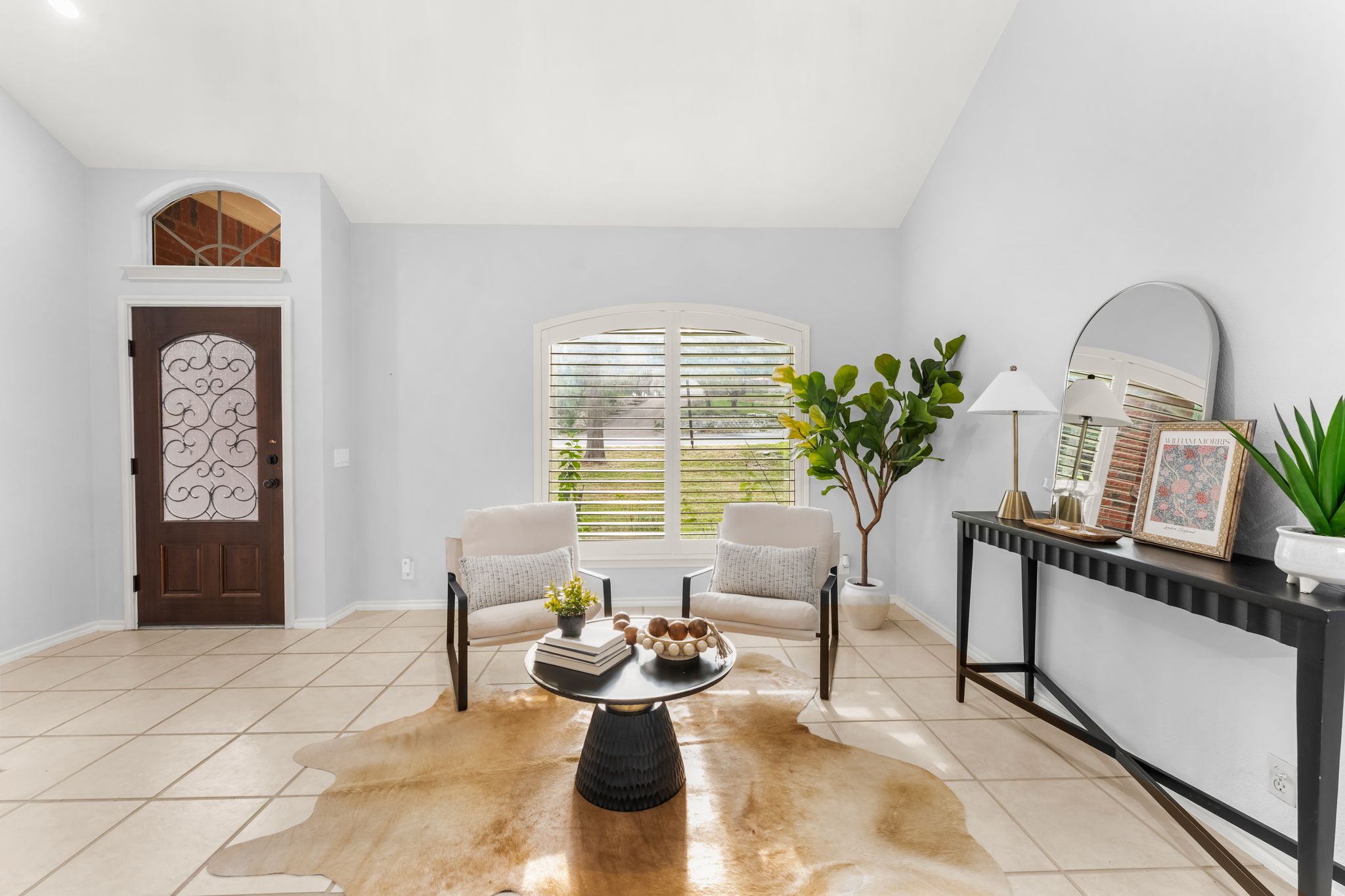 3704 Caney Creek Road Austin, TX 78732 - Photo 8 of 40 A graceful entry welcomes you into a brightly lit sitting area, complete with arched windows and light-colored tile flooring.