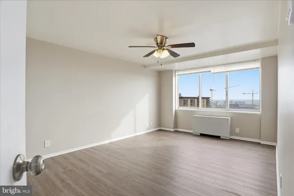 a view of an empty room with wooden floor