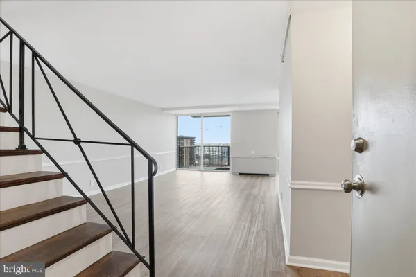 a view of a hallway with wooden floor and staircase