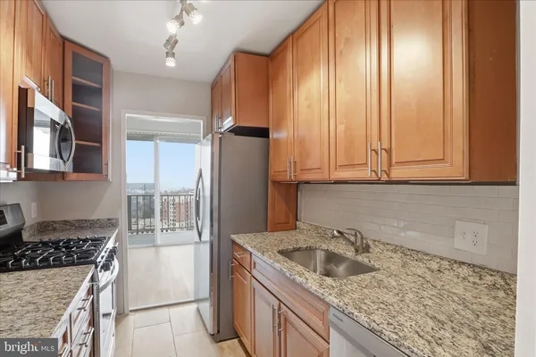 a kitchen with granite countertop a sink stove and cabinets