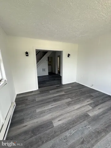 a view of a big room with wooden floor and windows