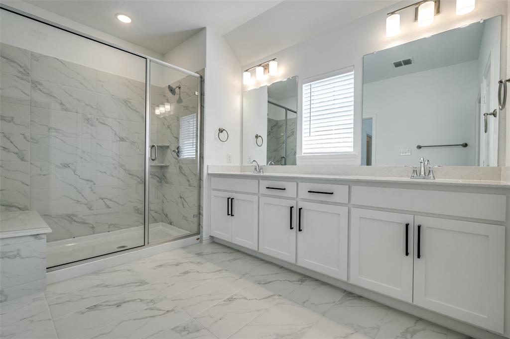 7336 Panicum Drive Frisco, TX 75033 - Photo 24 of 25 a bathroom with a shower sink and mirror