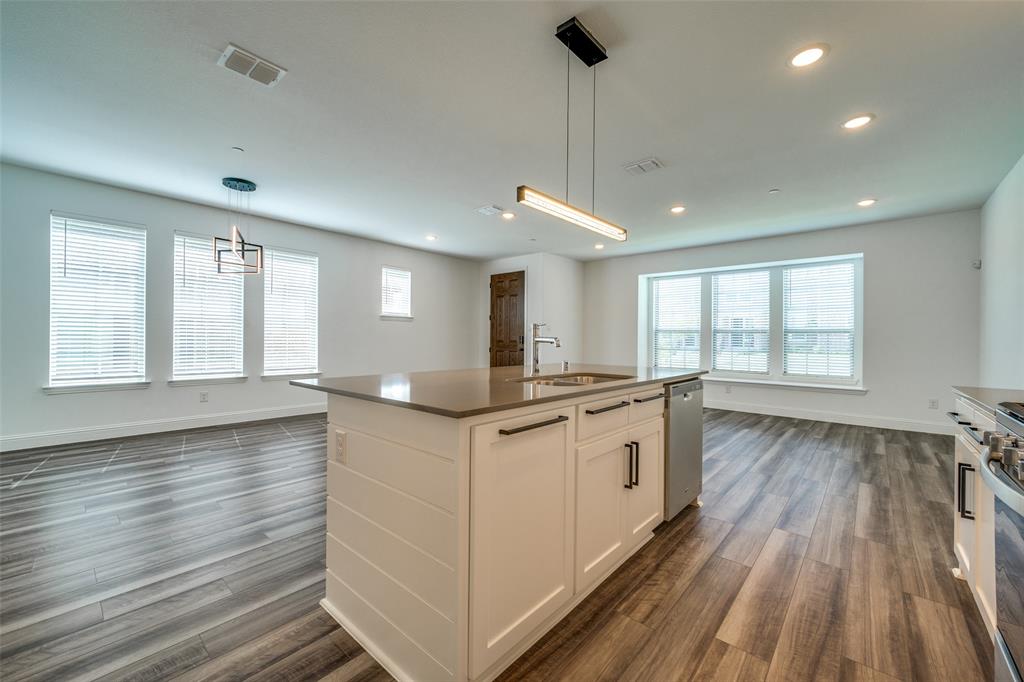 7336 Panicum Drive Frisco, TX 75033 - Photo 10 of 25 a large kitchen with granite countertop a large window and wooden floor