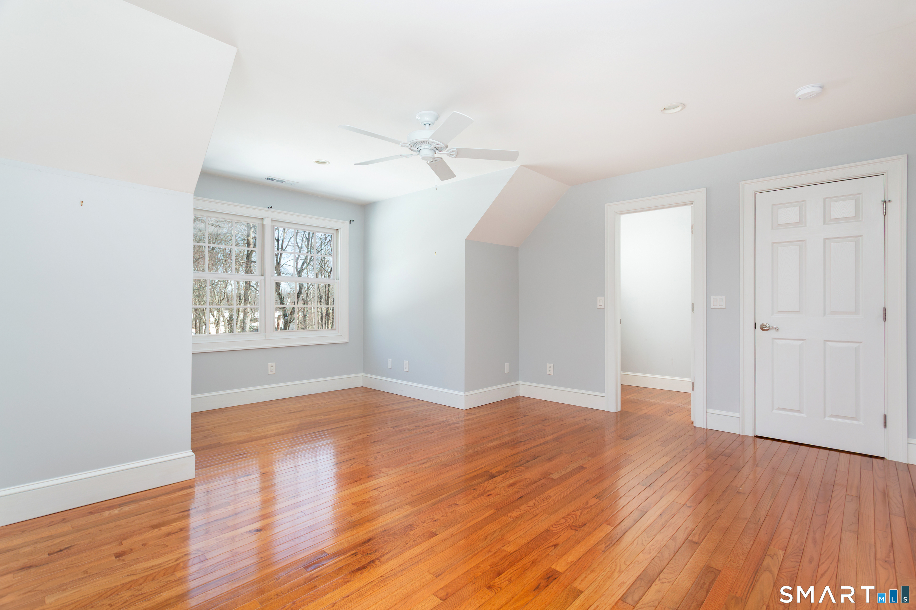 51 Wilson Road Easton, CT 06612 - Photo 32 of 41 an empty room with wooden floor chandelier fan and windows