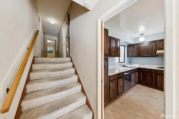 a view of a kitchen with cabinets and stainless steel appliances