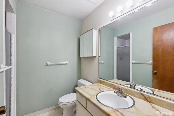 a picture of a room with a white bed and a white refrigerator