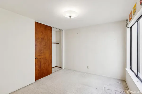 a view of an empty room with a fireplace and a window