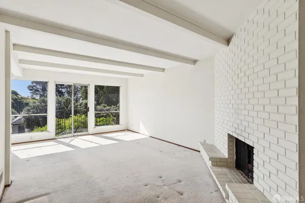 a view of an empty room with a fireplace