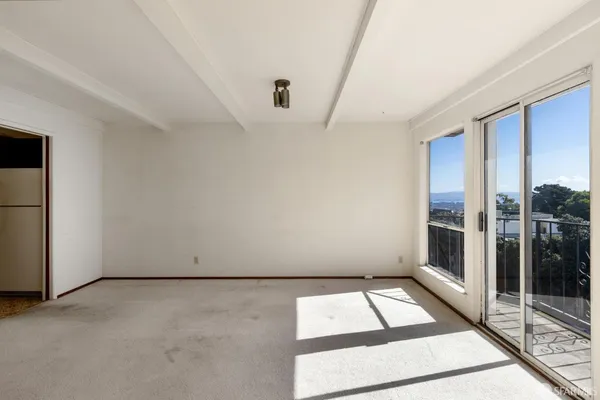 a view of a small space with wooden floor and a window