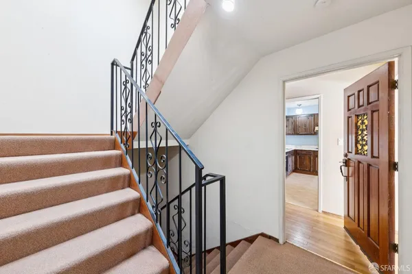 a view of staircase with lots of frames on wall and a window