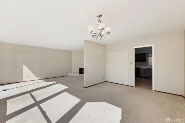 a view of an empty room with a chandelier
