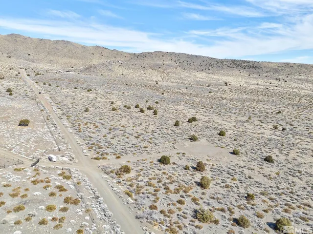 a view of a dry yard with wooden fence