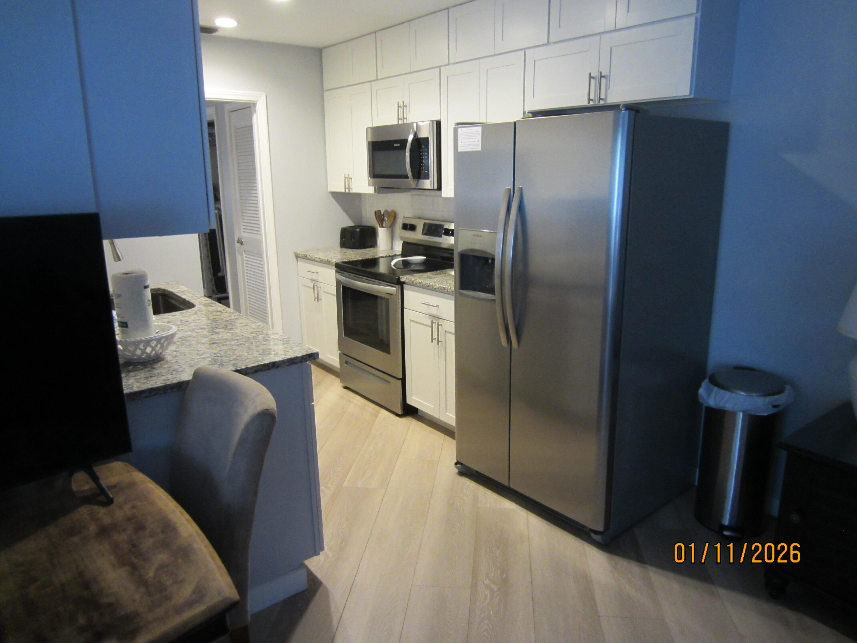 64 Cross Creek Road, Unit 24C Miramar Beach, FL 32550 - Photo 7 of 17 a kitchen with stainless steel appliances granite countertop a refrigerator a stove and a sink with wooden cabinets