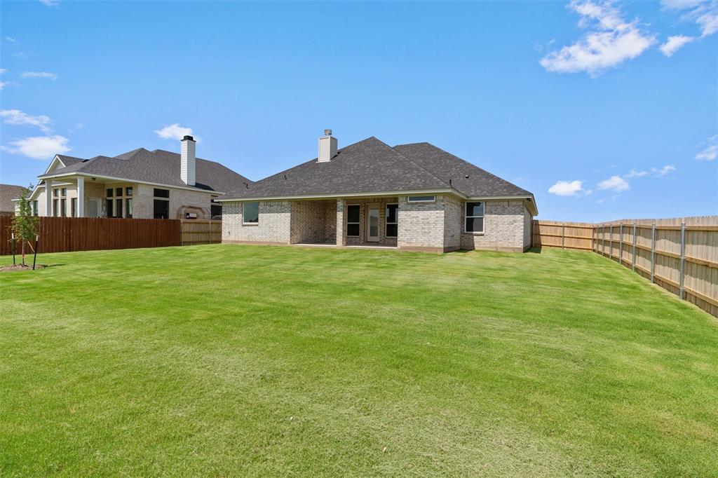 1341 Promised Land Road Hewitt, TX 76643 - Photo 26 of 29 Expansive backyard featuring a large green lawn, full privacy fencing, and an attached covered patio