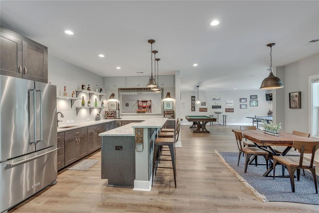 2503 Sugar Pike Road Canton, GA 30115 - Photo 122 of 134 a kitchen with stainless steel appliances granite countertop a refrigerator a stove top oven a sink dishwasher a dining table and chairs with wooden floor