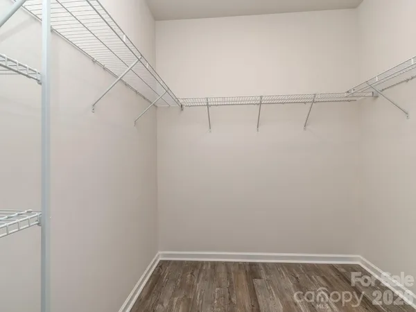 a view of walk in closet with racks on the wall