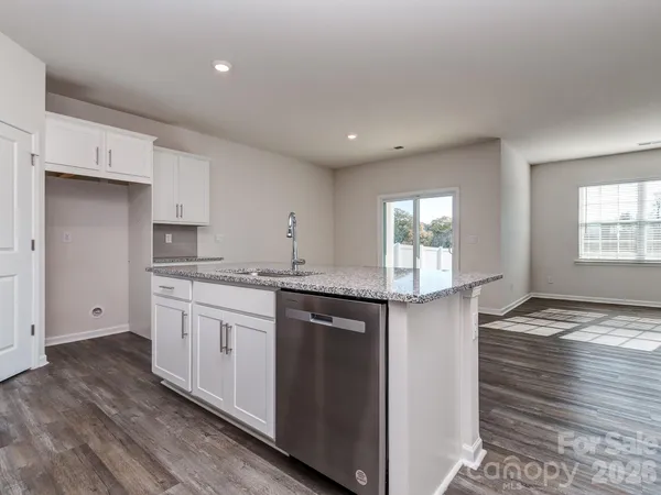 a kitchen with granite countertop a sink and a stove top oven