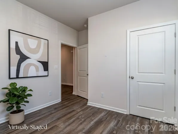 a view of a hallway with wooden floor and a potted plant