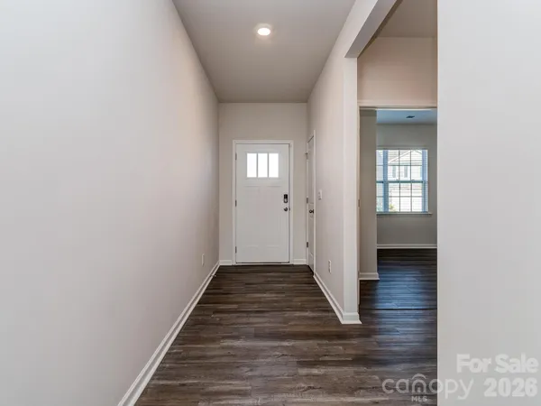 a view of a hallway with wooden floor and closet