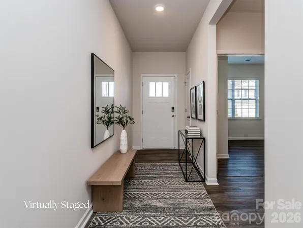 a view of a hallway with wooden floor and a living room