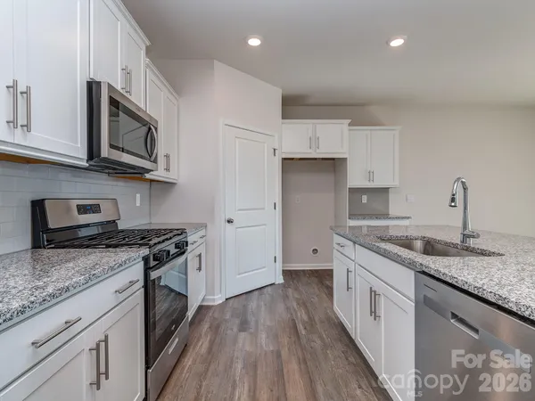 a kitchen with stainless steel appliances granite countertop a stove sink and cabinets