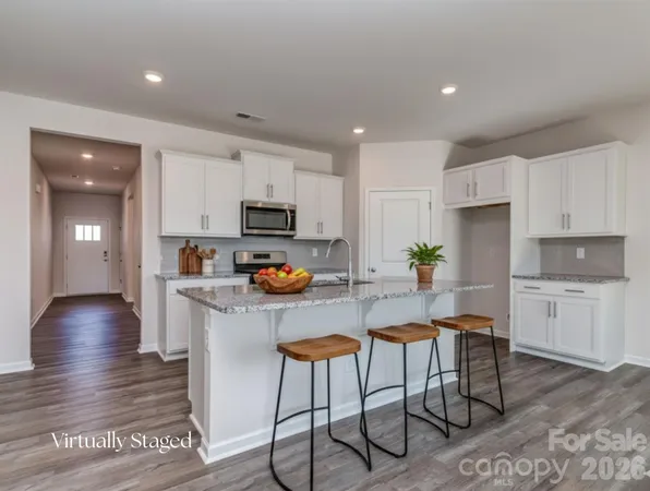 a kitchen with granite countertop white cabinets and stainless steel appliances