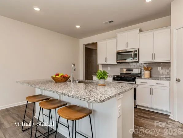 a kitchen with stainless steel appliances granite countertop a stove a sink cabinets and a refrigerator