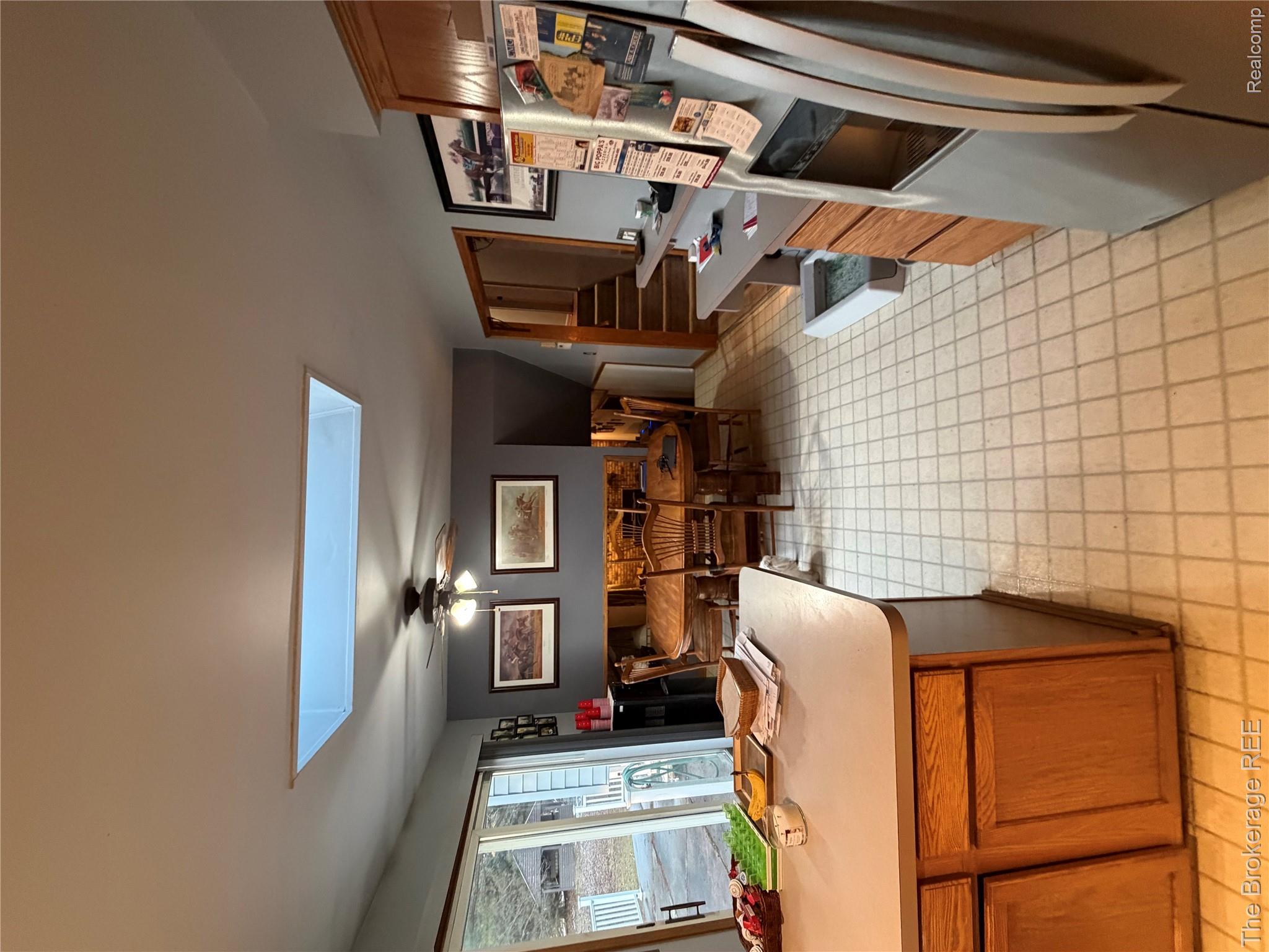 13405 Fagan Road Holly, MI 48442 - Photo 34 of 57 Kitchen featuring stainless steel fridge with ice dispenser, wood finish cabinets, a skylight, ceiling fan, and light countertops