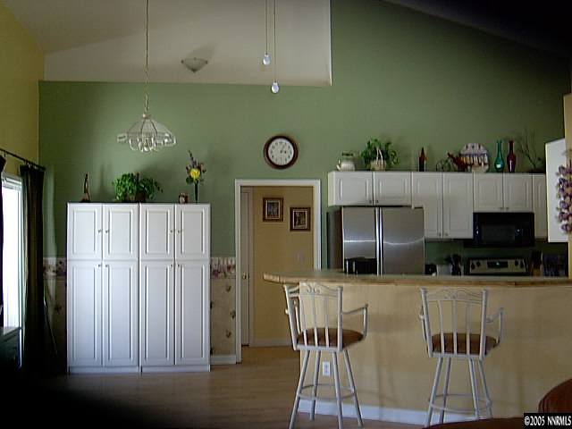 2420 Grizzley Road Reno, NV 89521 - Photo 4 of 9 a kitchen with stainless steel appliances kitchen island granite countertop a refrigerator a stove a sink and a microwave oven with wooden floor