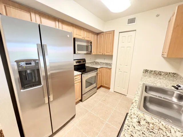 a kitchen with granite countertop a refrigerator and a sink
