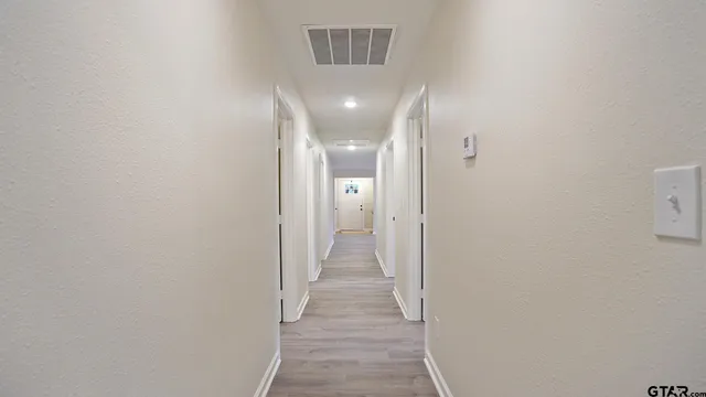 a view of a hallway with wooden floor
