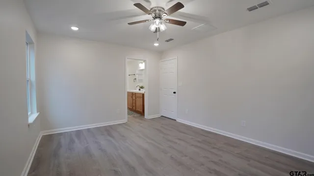 a view of a livingroom with a ceiling fan and wooden floor