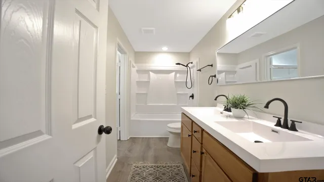 a bathroom with a sink and mirror with toilet