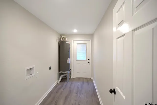 a view of a hallway with wooden floor and closet area